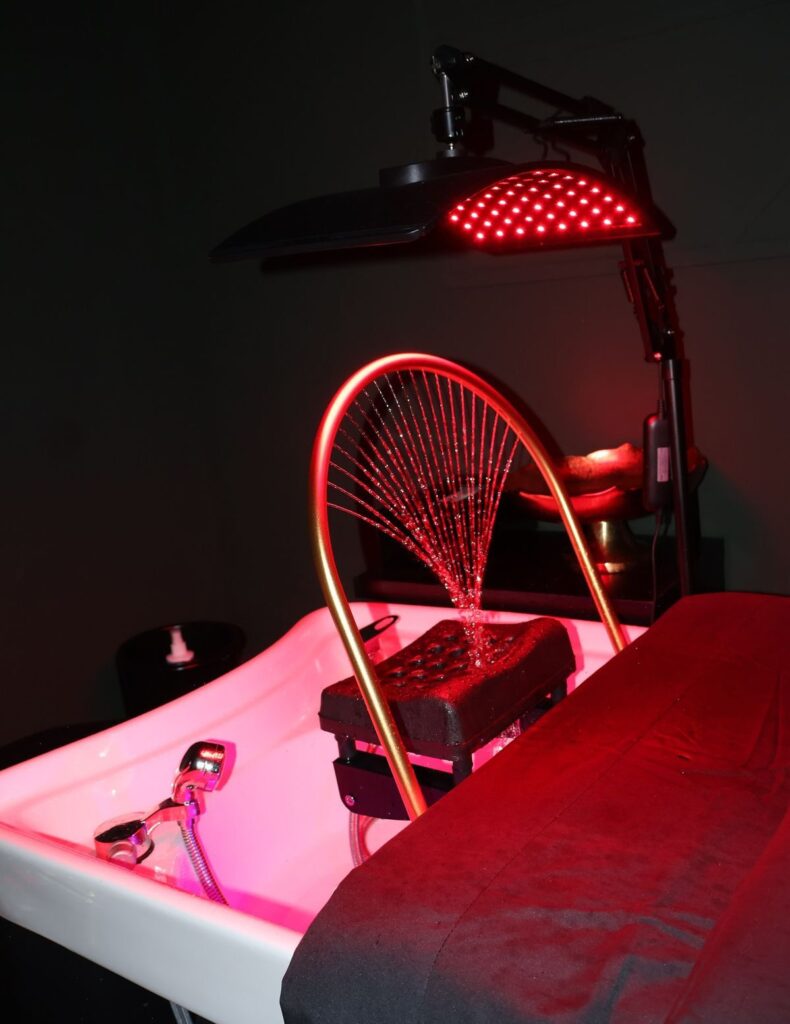 Ein moderner Haarwaschplatz mit rotem LED-Licht und geschwungenem Wasserbogen